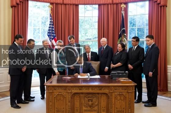 President Barack Obama signs H.R. 205, the HEARTH Act of 2012, in the Oval Office, July 30, 2012. Standing behind the President, from left, are: Bryan Newland, Senior Policy Advisor at the Department of the Interior; Governor Randall Vicente, Pueblo of Acoma in New Mexico; David Hayes, Deputy Secretary of the Department of the Interior; Jefferson Keel, President of the National Congress of American Indians; Rep. Martin Heinrich, D-N.M.; Sen. Daniel Akaka, D-Hawaii; interior Secretary Ken Salazar; Cheryl Causley, Chairperson of the National American Indian Housing Council; Governor Gregory Mendoza, Gila River Indian Community of Arizona; and Del Laverdure, Acting Assistant Secretary of the Department of the Interior. (Official White House Photo by Pete Souza)