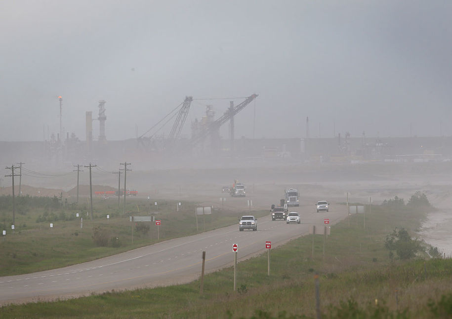 Trucks leave the Syncrude mine site north of Fort McMurray, Alberta on June 3, 2016. .Production at the plant continues after being briefly suspended during last month's raging forest fires threatened to burn through to the plant. / AFP / Cole Burston (Photo credit should read COLE BURSTON/AFP/Getty Images)