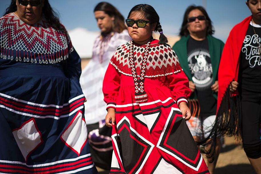 Women and girls from the Colorado River Indian tribes dance after arriving at a protest encampment near Cannon Ball, North Dakota to lend their support to the Standing Rock Sioux Tribe's opposition to the Dakota Access Pipeline (DAPL) September 3, 2016..Drive on a state highway along the Missouri River, amid the rolling hills and wide prairies of North Dakota, and you'll come across a makeshift camp of Native Americans -- united by a common cause. Members of some 200 tribes have gathered here, many raising tribal flags that flap in the unforgiving wind. Some have been here since April, their numbers fluctuating between hundreds and thousands, in an unprecedented show of joint resistance to the nearly 1,200 mile-long Dakota Access oil pipeline. / AFP / Robyn BECK (Photo credit should read ROBYN BECK/AFP/Getty Images)
